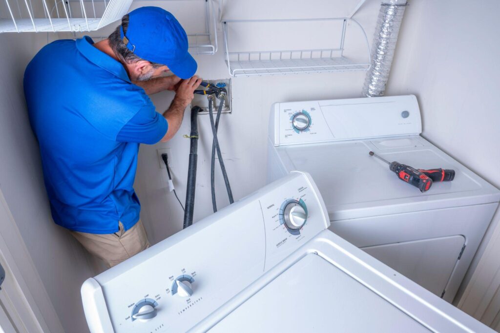 Plumber installing a residential washing machine